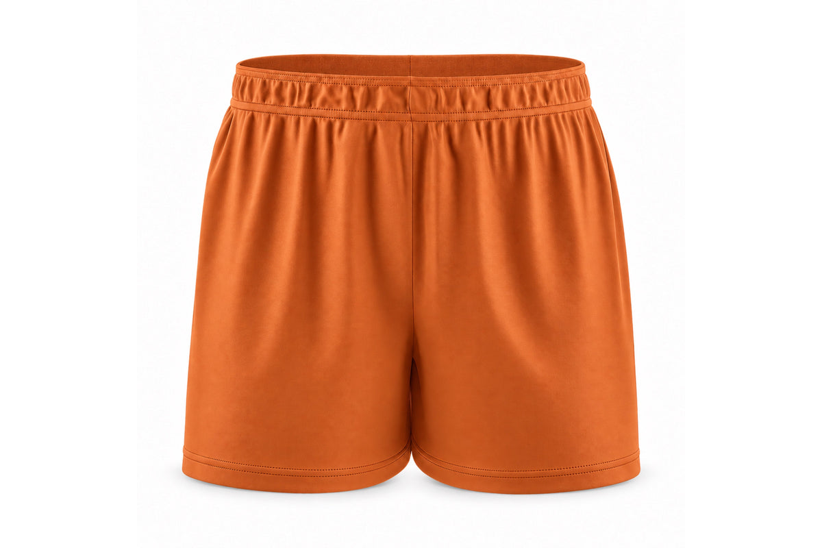 Front view of blank burnt orange custom sublimated athletic shorts with elastic waistband and stitched hems on a white background.