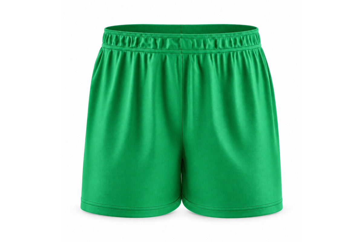 Front view of blank kelly green custom sublimated athletic shorts with elastic waistband and stitched hems on a white background.