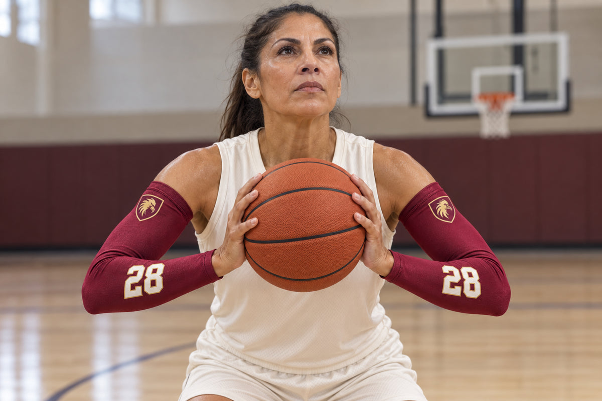 Basketball player setting up a jump shot in Maroon custom arm sleeves with a griffin crest and number 28