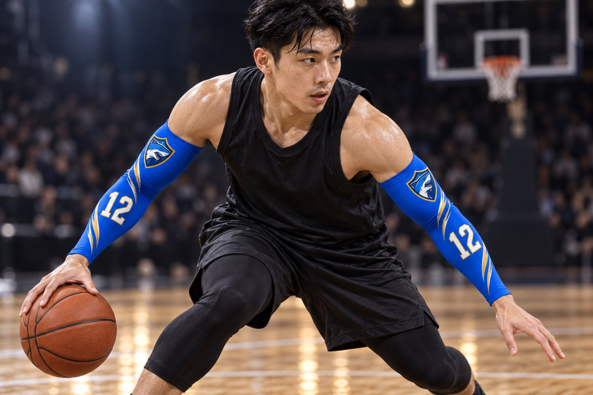 Basketball guard dribbling through a crossover in Royal Blue custom arm sleeves with a shark crest and number 12