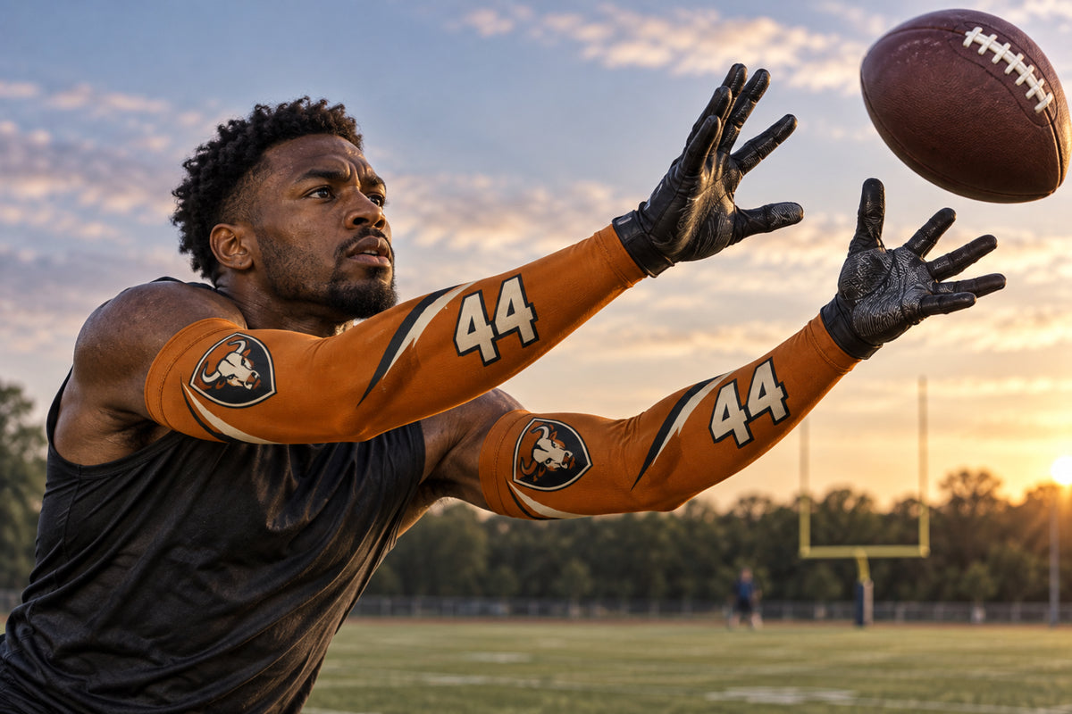 Defensive back reaching to break up a pass in Burnt Orange custom arm sleeves with a bull crest and number 44