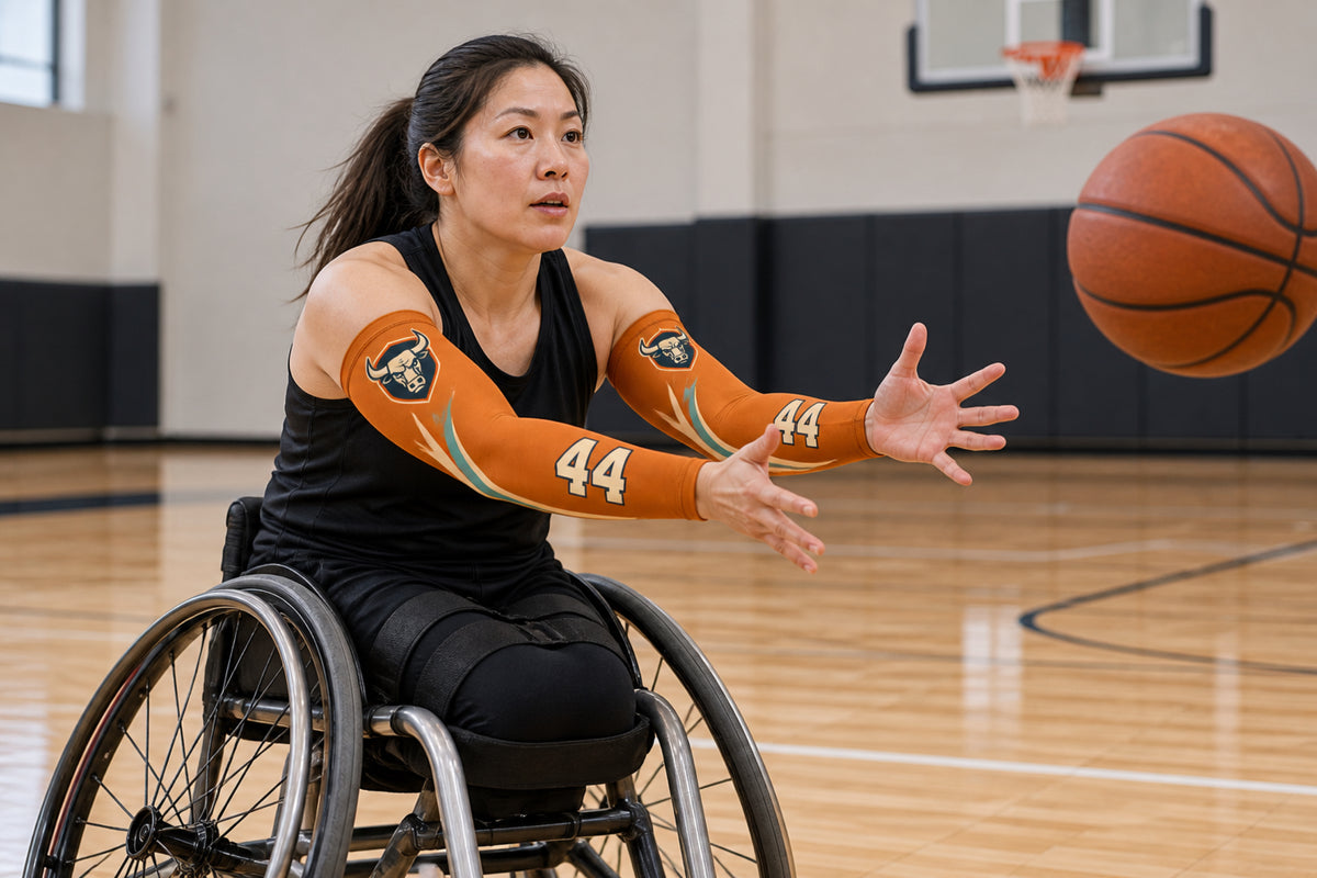 Wheelchair basketball player receiving a pass in Burnt Orange custom arm sleeves with a bull crest and number 44