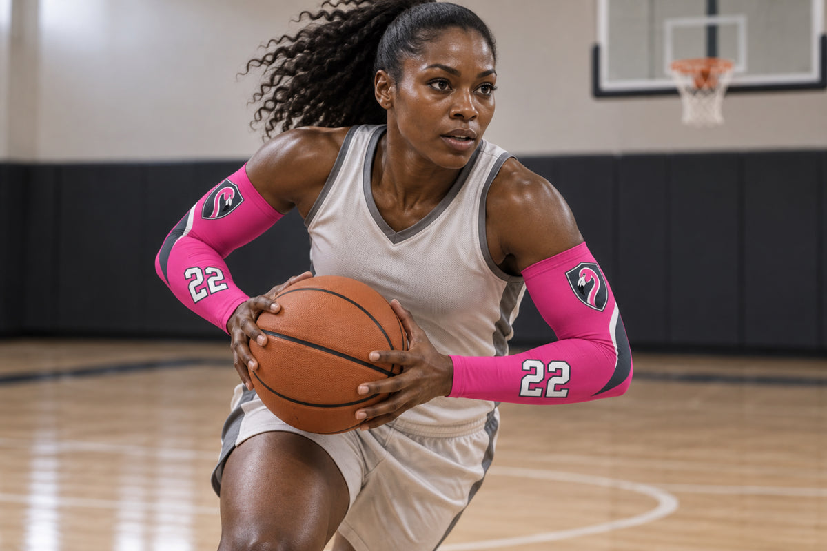 Basketball player attacking the rim in Hot Pink custom arm sleeves with a flamingo crest and number 22