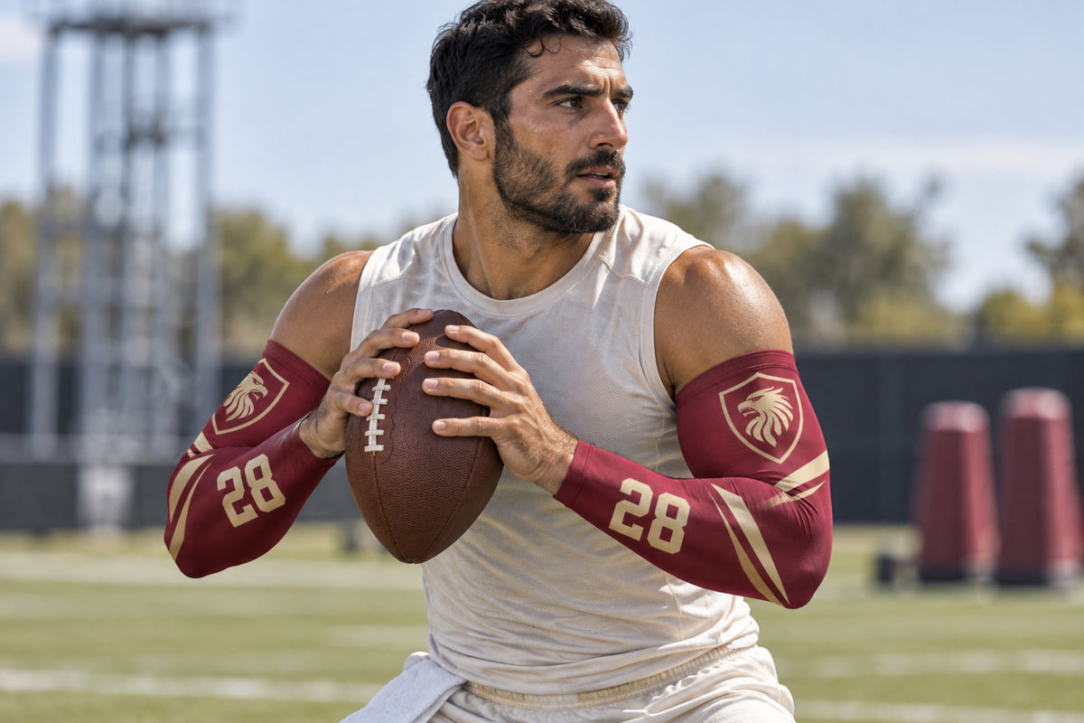 Quarterback holding the ball and reading the field in Maroon custom arm sleeves with a griffin crest and number 28