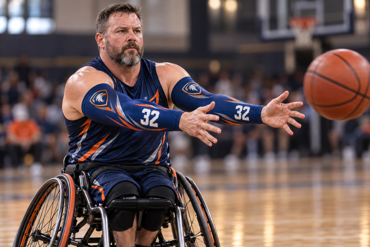 Wheelchair basketball player making a chest pass in Navy custom arm sleeves with a hawk crest and number 32