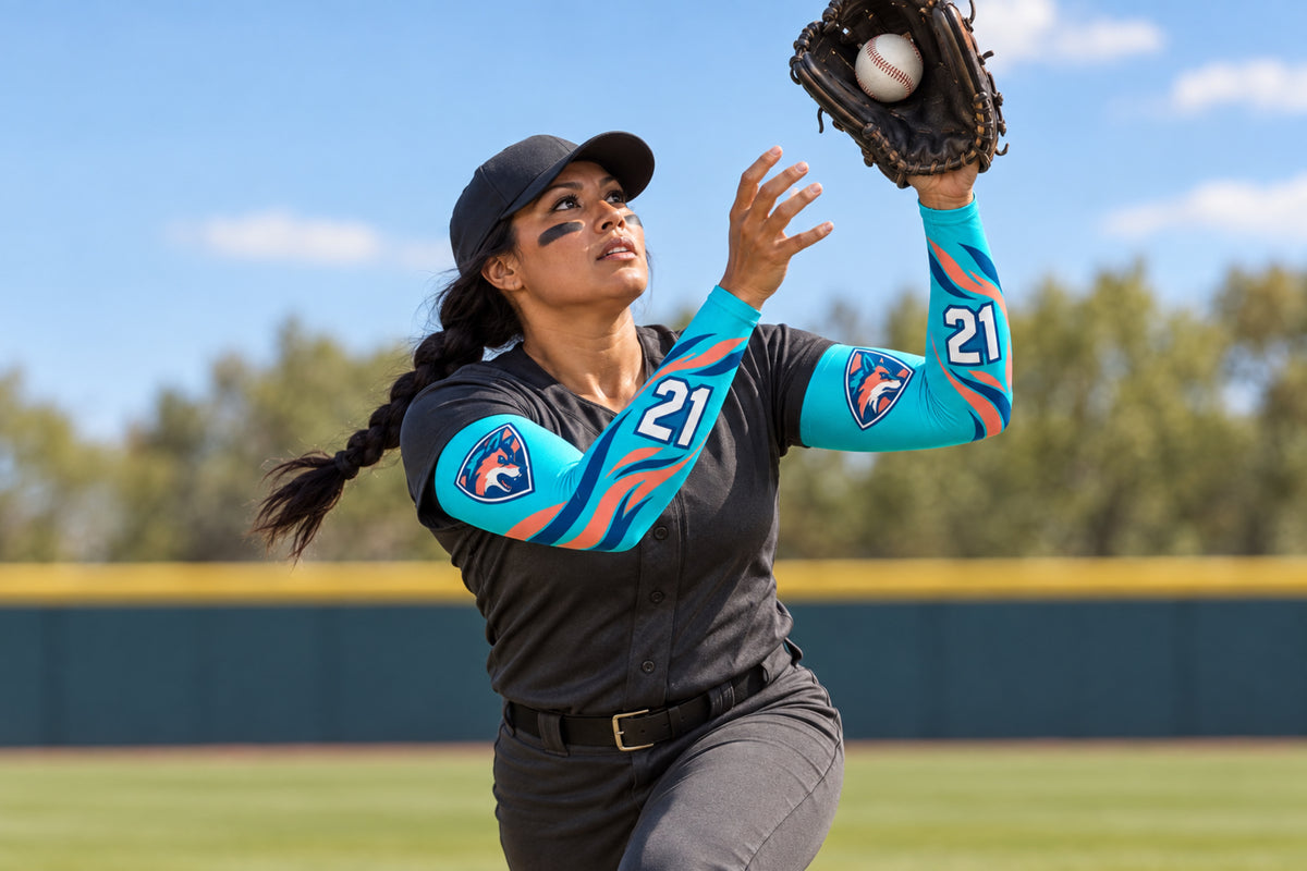 Outfielder catching a fly ball in Turquoise custom arm sleeves with a coyote crest and number 21