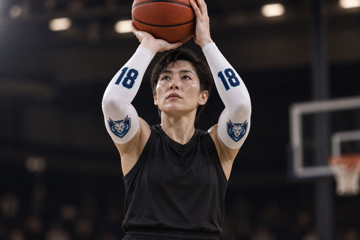 Basketball player rising for a jump shot in White custom arm sleeves with a lynx crest and number 18